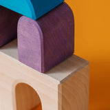 Close up of a purple tactile piece from the Grimm's wooden floor building set, shows hand carved detail