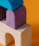 Close up of a purple tactile piece from the Grimm's wooden floor building set, shows hand carved detail