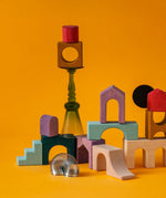 Loose wooden tactile pieces from Grimm's wooden floor set against a orange background.