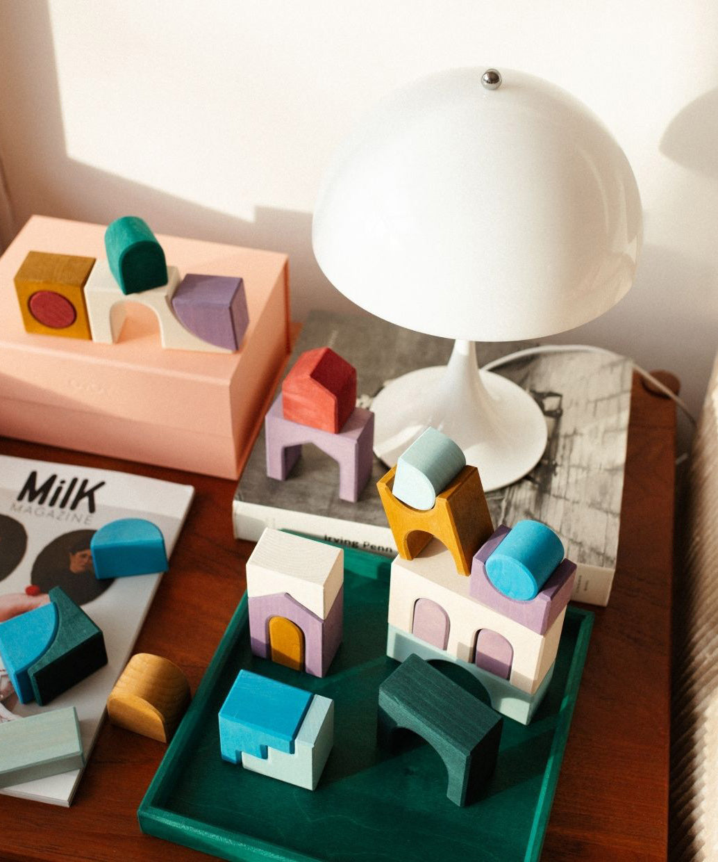 Loose hand crafted pieces from the Grimms floor building set on a table in a bedroom setting