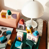 Loose hand crafted pieces from the Grimms floor building set on a table in a bedroom setting