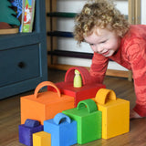 A child playing a sorting game with the Grimm's Large Coloured Boxes Set and mini arch pieces
