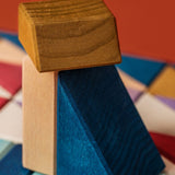 A close of a brown, blue and white wooden tactile piece from the Grimms rhythm set showing the hard carved detail