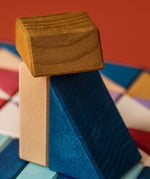 A close of a brown, blue and white wooden tactile piece from the Grimms rhythm set showing the hard carved detail