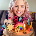 A child is celebrating their 8th birthday and has in front of them, a Grimm's Waldorf celebration ring filled with Grimm's decorative figures, a candle and a Grimm's number 8. In the centre is a Grimm's 6 piece mini wooden rainbow.
