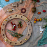 A beautiful Autumnal display using a Grimm's Celebration Ring, loose parts laid on top of decorative scarfs