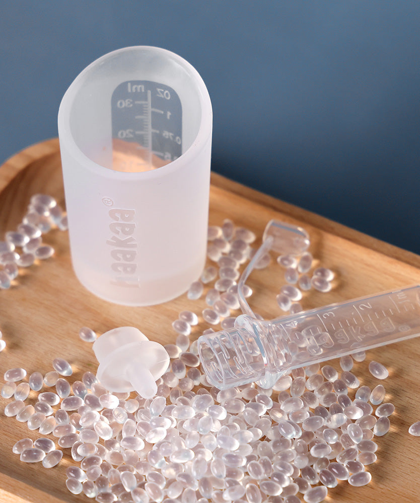 Haakaa colostrum storage tube next to a collector containter.