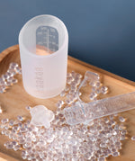 Haakaa colostrum storage tube next to a collector containter.