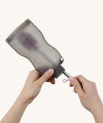 The Haakaa Silicone Cleaning Brush being used to clean a Haakaa food pouch