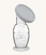 Haakaa Generation 2 Silicone Breast Pump with Suction Base and grey cap on a cream background