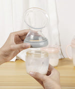 A person attaching the Haakaa Generation 3 Silicone Breast Pump Flange Attachment to a Haakaa baby Bottle