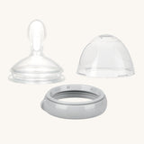 The Haakaa Generation 3 Silicone Bottle Feeding Spoon Head, on a cream background. The set come with the Silicone Feeding Spoon, Cap and ring in grey