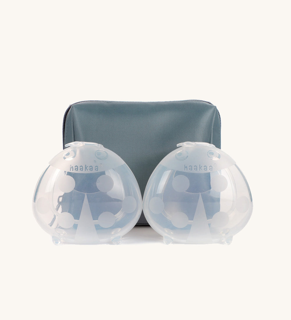 Haakaa Ladybug Silicone Breast Milk Collector standing in front of slate blue storage bag 