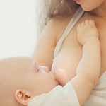 A person wearing The Haakaa Silicone Nipple Shield whilst their baby is breastfeeding 