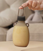 A person holding The Haakaa Happii Bear Silicone Goody Pouch on their finger to show the durability of the pouch lid