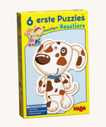 A yellow cardboard box with a picture of a dog puzzle on the front for the Haba 6 animal puzzle set on a cream background.