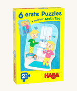 A yellow cardboard box with a picture of a boy and girl brushing their teeth for the Haba my day jigsaw set on a cream background