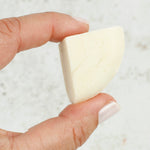 A person holding a piece of the Shower Blocks 1/4 Bar Sample - Sweet Orange & Bergamot