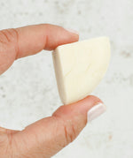 A person holding a piece of the Shower Blocks 1/4 Bar Sample - Sweet Orange & Bergamot