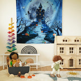 The Wonderie Play Cloth - Spooky Manor hanging up on a wall in a play room. The image shows Halloween toys, a dolls house, a Grimm's rainbow and a marble tree 