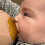 Hevea Natural Rubber Nipple Shields on a breast with baby feeding. 