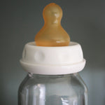 Hevea natural rubber teat on a glass baby bottle. 