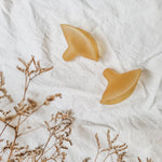 Hevea Natural Rubber Nipple Shields - 2 Pack side view on a white cotton sheet.