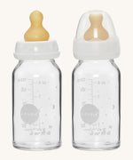A pack of two Hevea glass baby bottles 120ml with natural rubber teats, one with the dust cap, one without. 