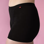 Hey Girls My Period Shorts from the side, in Black on a pink background