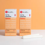 Hey Girls Tampons in Regular and Super Absorbency boxes, with the tampons in front. On an orange and white background