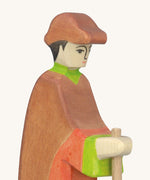 A close up of the wooden Holztiger wooden shepherd figure showing the hand painted detail on the face and the brown cap on the head