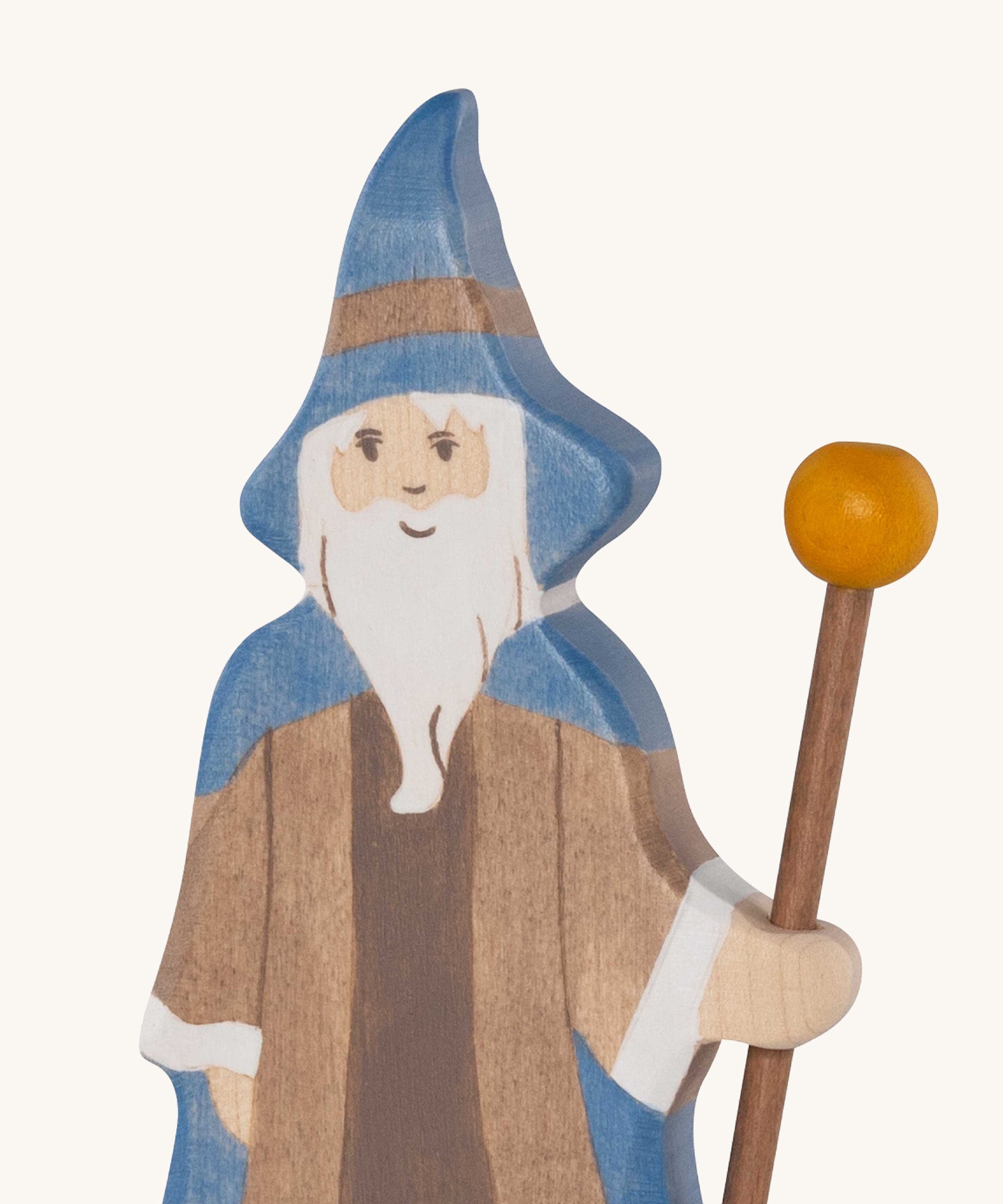 A close up of the Holztiger wooden bearded magician figure showing the hand painted facial features and blue hat while holding  a wooden staff
