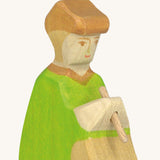 A close up of the sitting Holztiger wooden green shepherd figure showing the hand painted facial features 