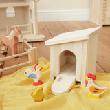 Holztiger wooden small animal shelter toy used as a chicken coop with removable roof and opening door/ramp, set up with a Holztiger hen, chick and cockerel. 