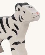 A close up of the Holztiger wooden standing white baby tiger with black stripes, showing the hand painted facial features