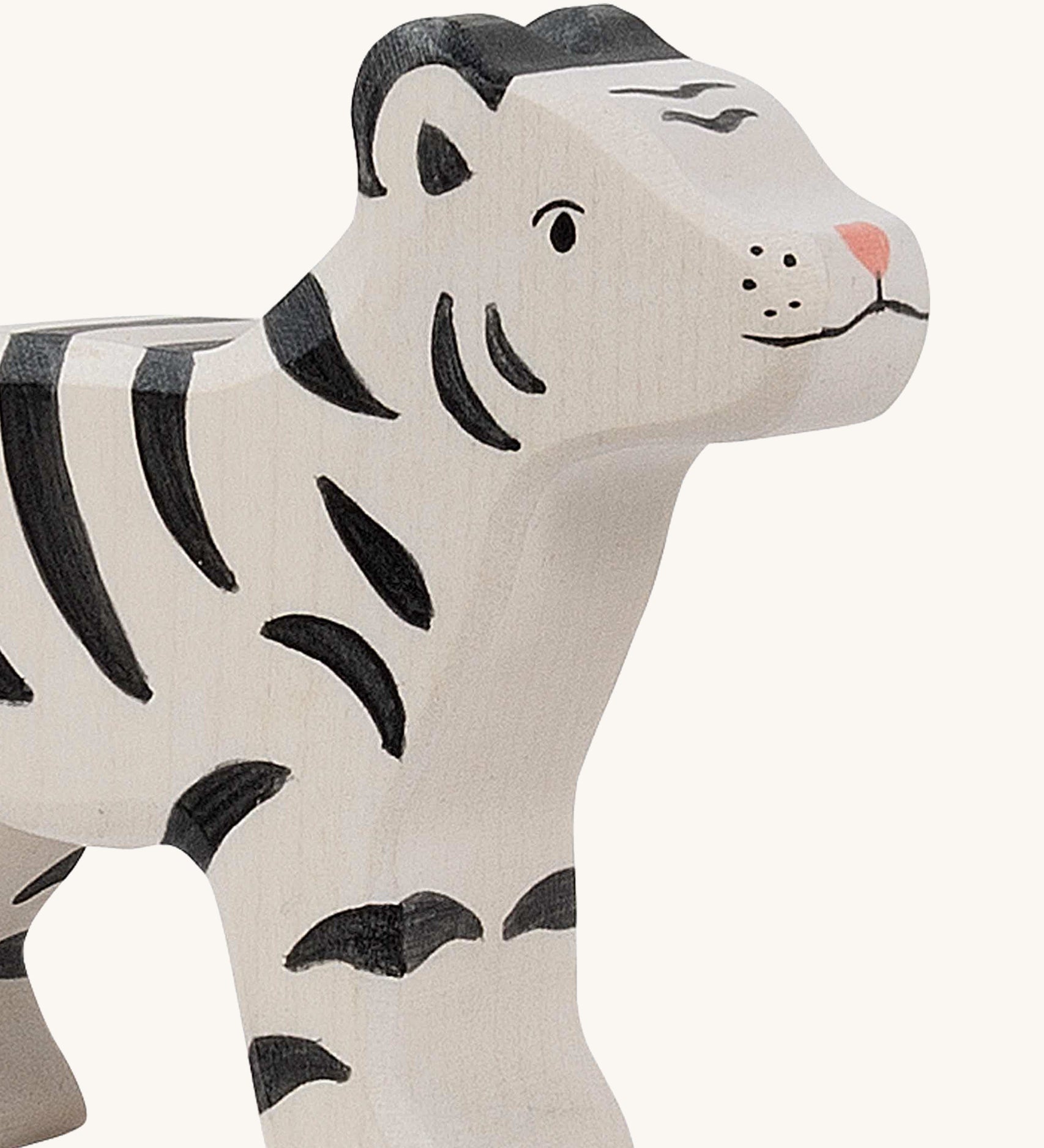 A close up of the Holztiger wooden standing white baby tiger with black stripes, showing the hand painted facial features