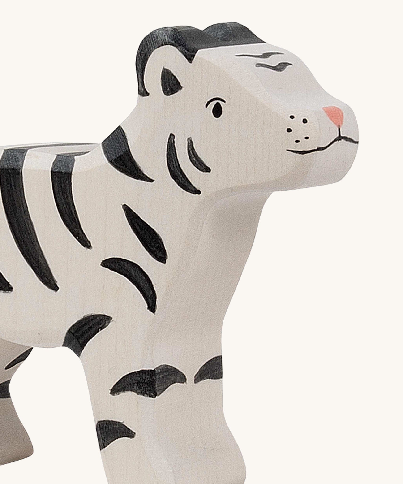 A close up of the Holztiger wooden standing white baby tiger with black stripes, showing the hand painted facial features