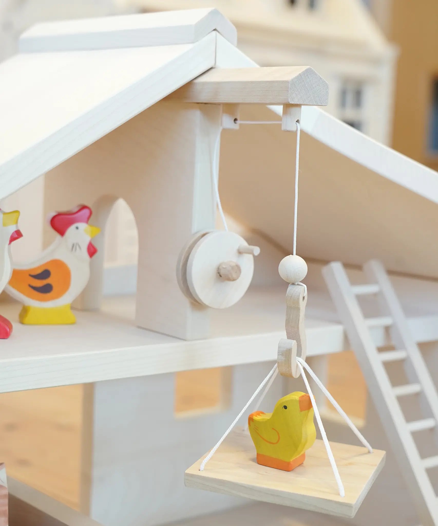 Holztiger Wooden Stable Toy With working Rope Winch carrying a Holztiger chick.