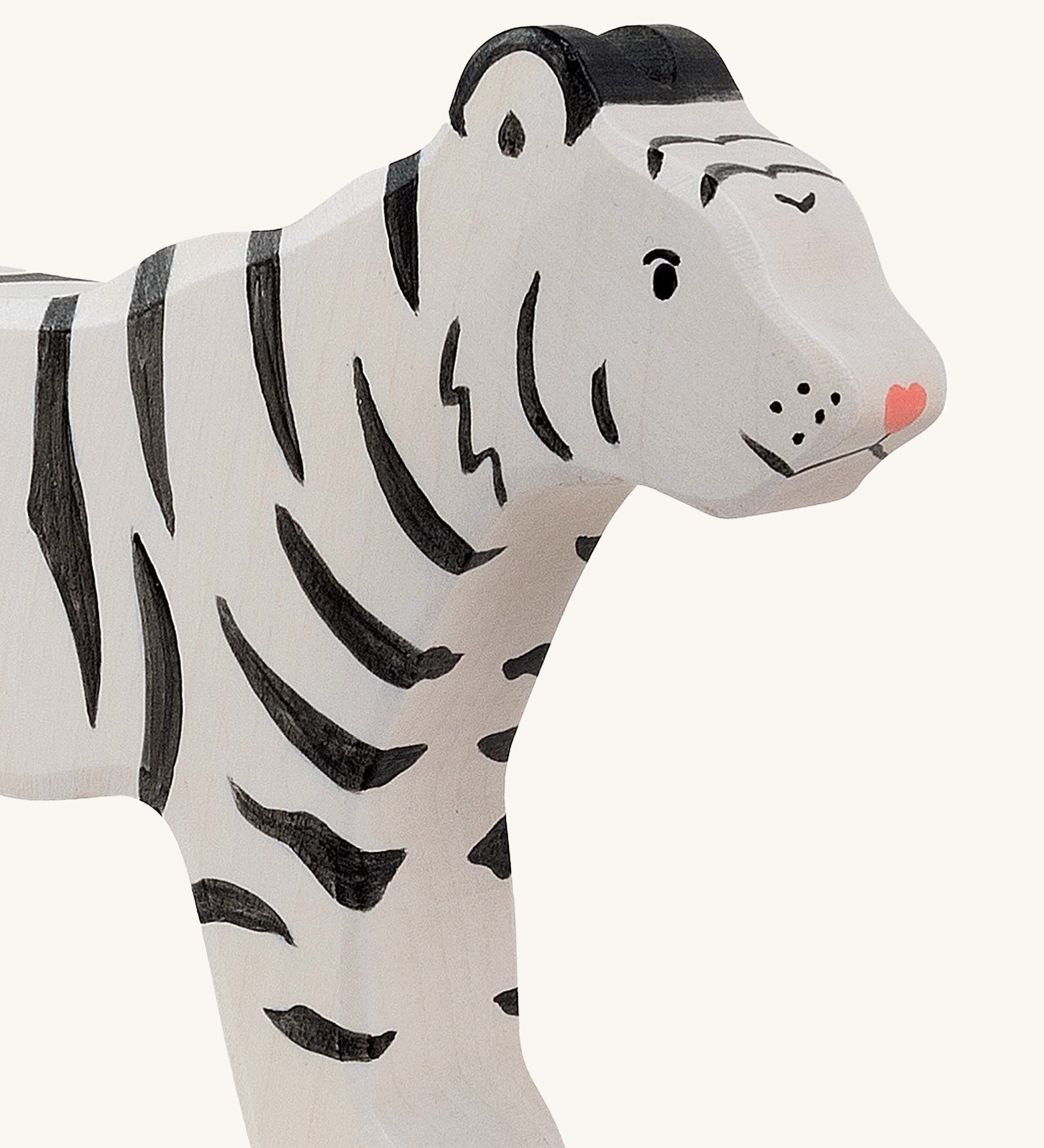 A close up of the Holztiger wooden standing white adult tiger with black stripes showing the hand painted facial features