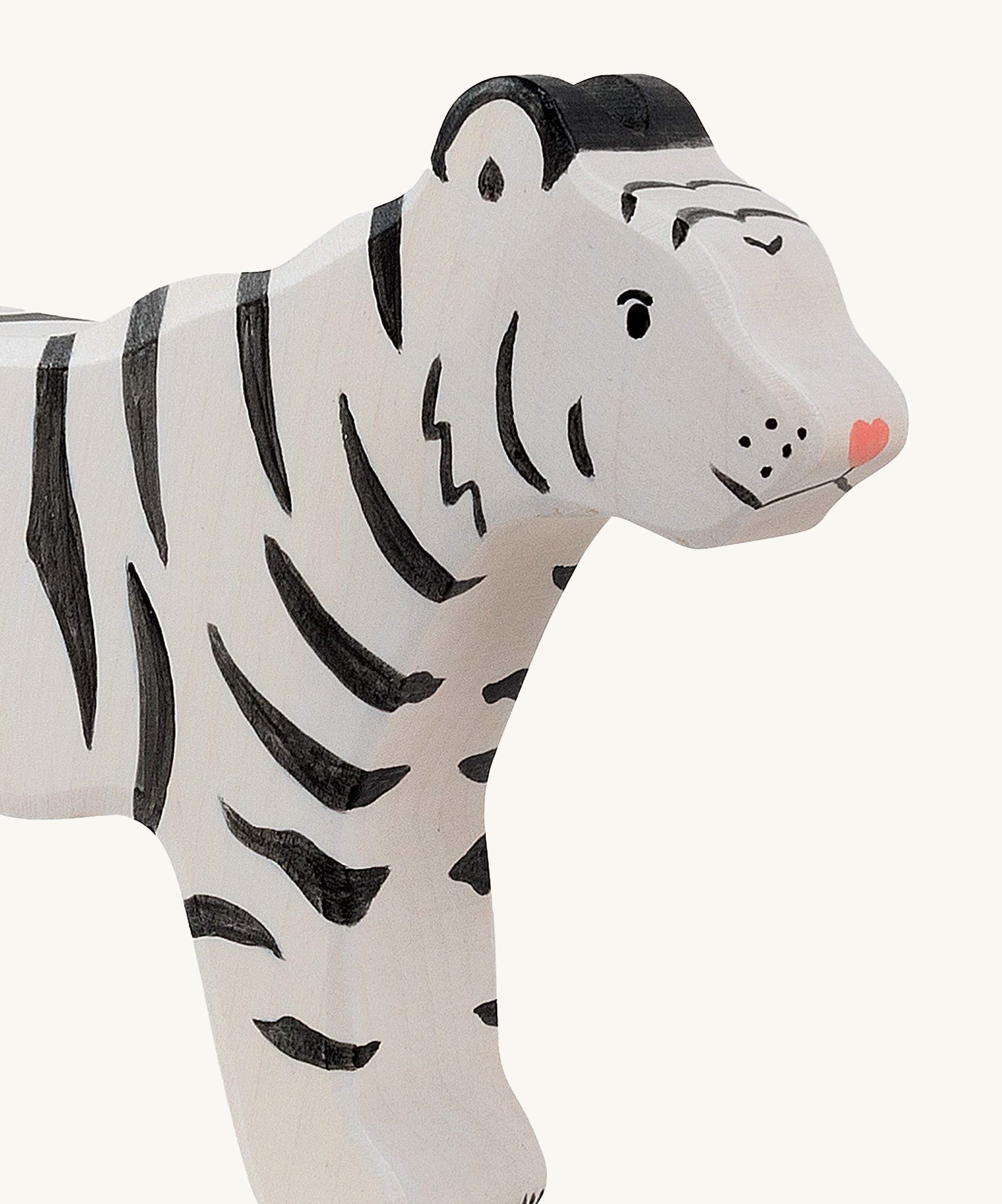 A close up of the Holztiger wooden standing white adult tiger with black stripes showing the hand painted facial features