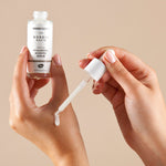 A person applying the Green People Nordic Roots Hyaluronic Booster Serum onto their hand to show the silky texture and white colour of the serum. 
