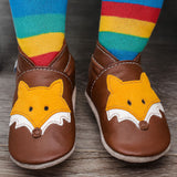 A close up of a child wearing the Inch blue chocolate Mr Fox baby shoe showing the ankle cuff detail and the cute playful suede fox