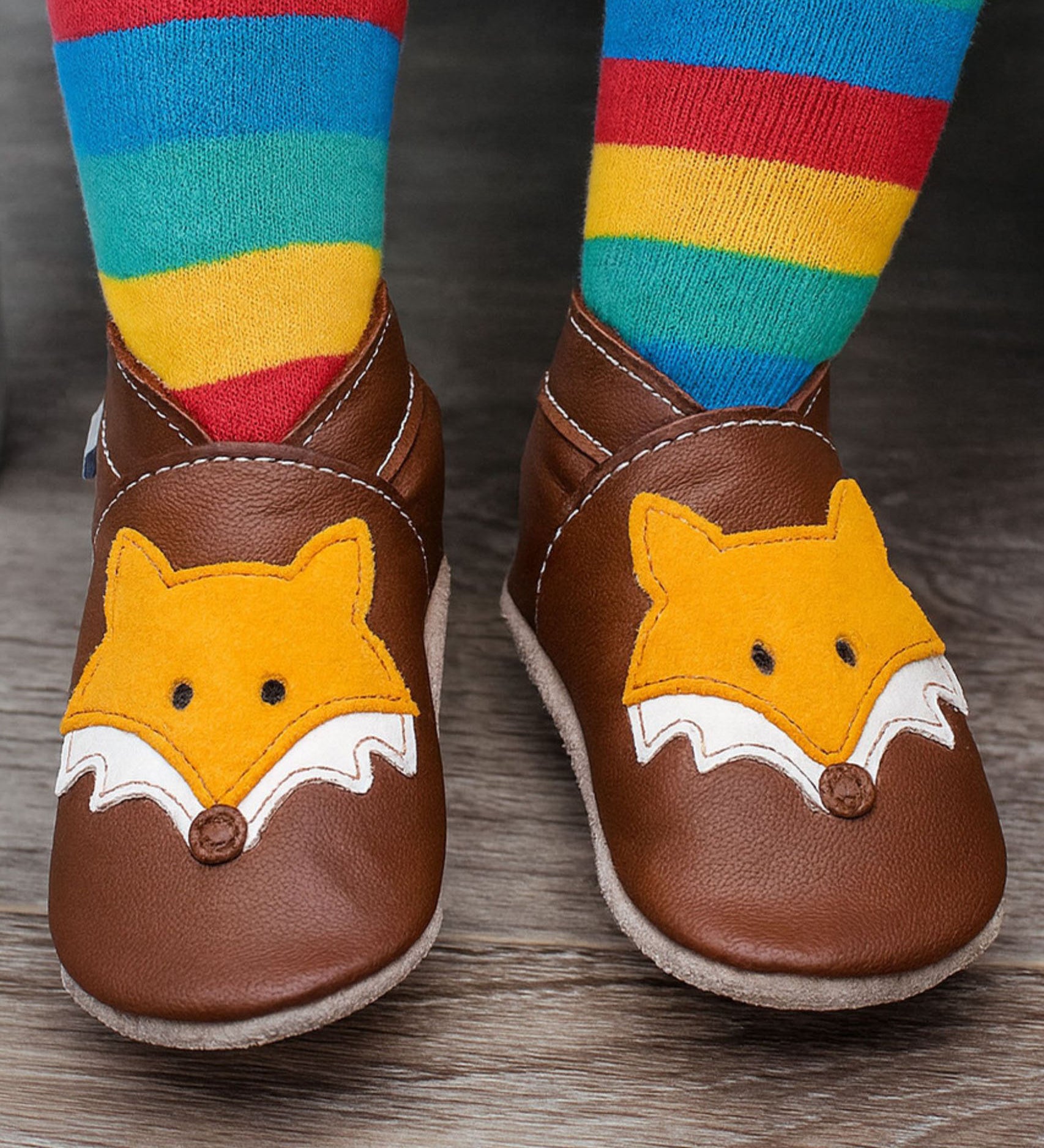 A close up of a child wearing the Inch blue chocolate Mr Fox baby shoe showing the ankle cuff detail and the cute playful suede fox