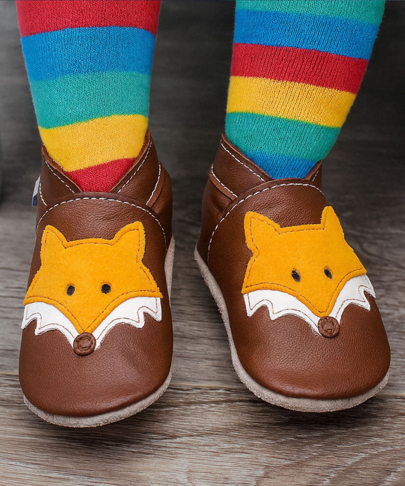 A close up of a child wearing the Inch blue chocolate Mr Fox baby shoe showing the ankle cuff detail and the cute playful suede fox