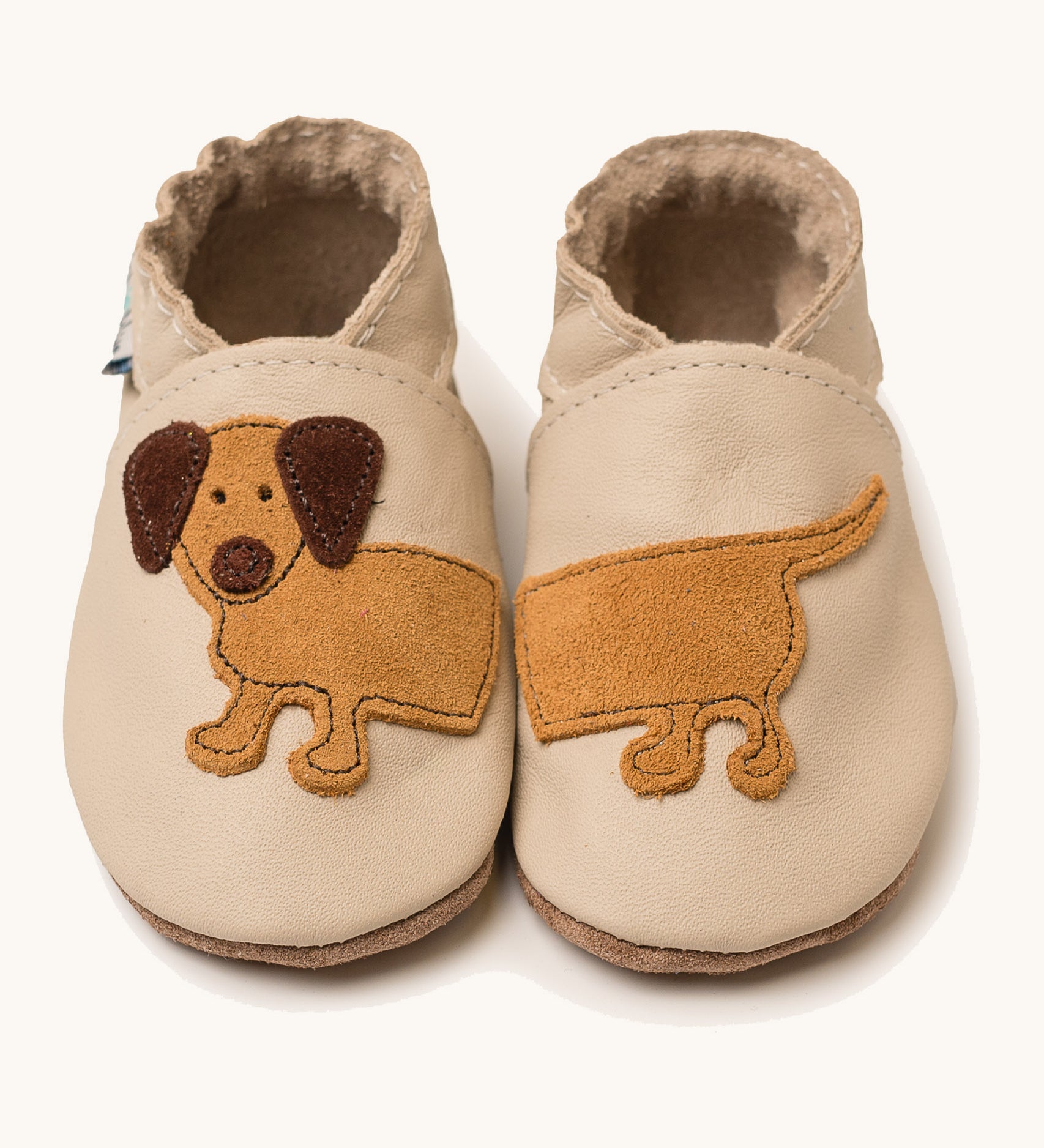 Inch Blue cream dash shoes available at Babipur. A soft cream baby leather shoe with cute playful suede dashchund design. Features elastic ankle cuffs for a secured fit