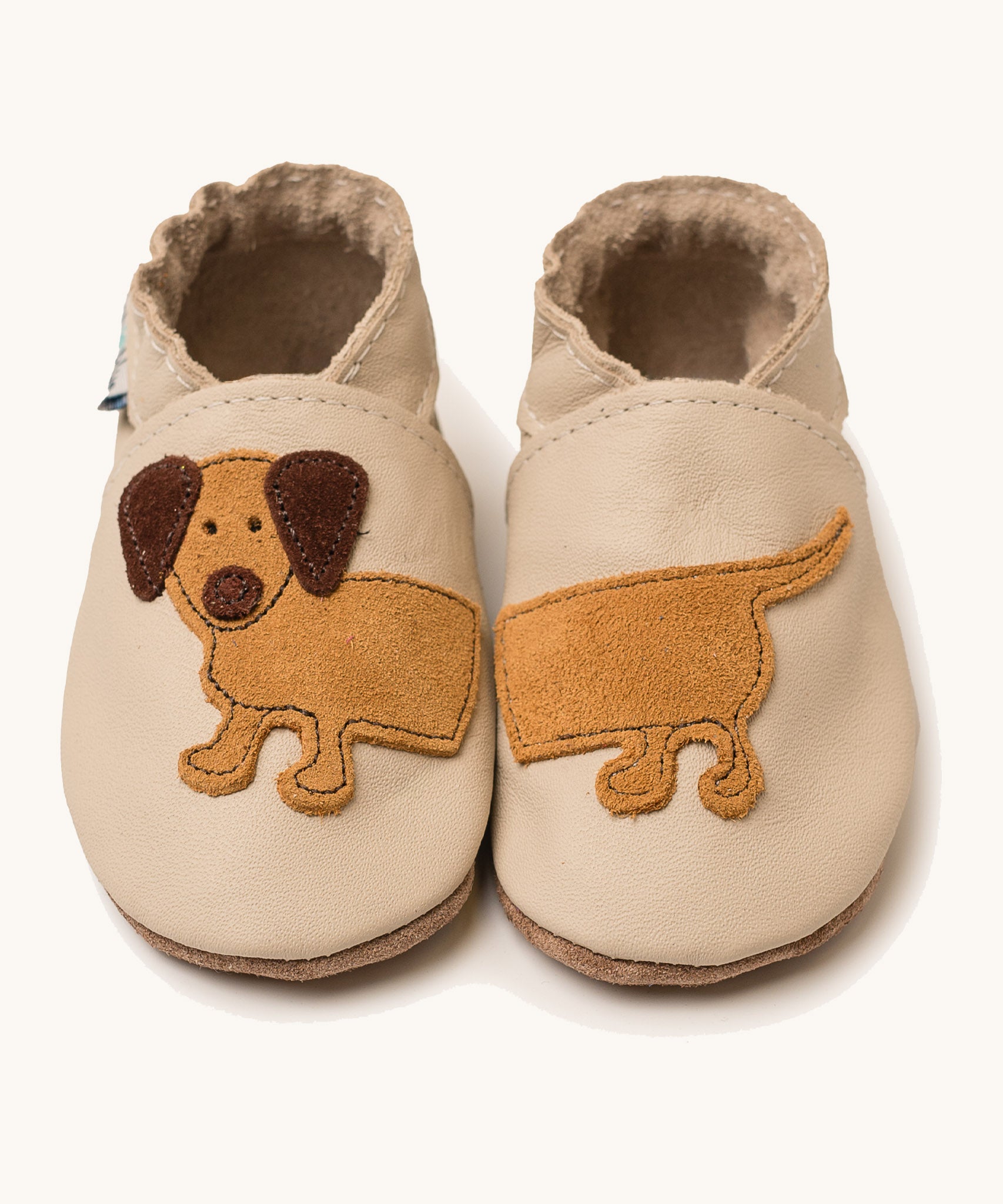 Inch Blue cream dash shoes available at Babipur. A soft cream baby leather shoe with cute playful suede dashchund design. Features elastic ankle cuffs for a secured fit