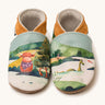 Inch Blue highland cow shoes available at Babipur. A soft baby leather shoe with a playful highland cow and the loch ness monster design. Features elastic ankle cuffs for a secured fit