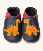 Inch Blue navy dino baby shoes available at Babipur. A soft navy baby leather shoe with a cute playful orange suede dinosaur on each shoe. Features elastic ankle cuffs for a secured fit