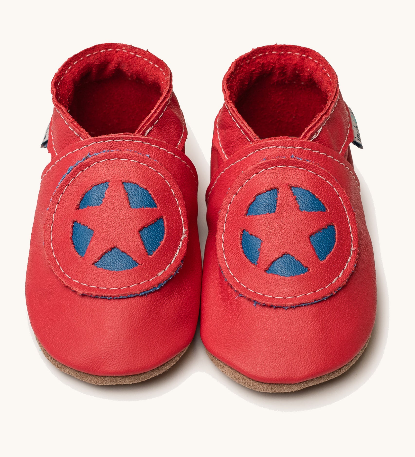 Inch Blue superkid red baby shoes available at Babipur. A soft red baby leather shoe with a red and blue star shield design on each shoe. Features elastic ankle cuffs for a secured fit