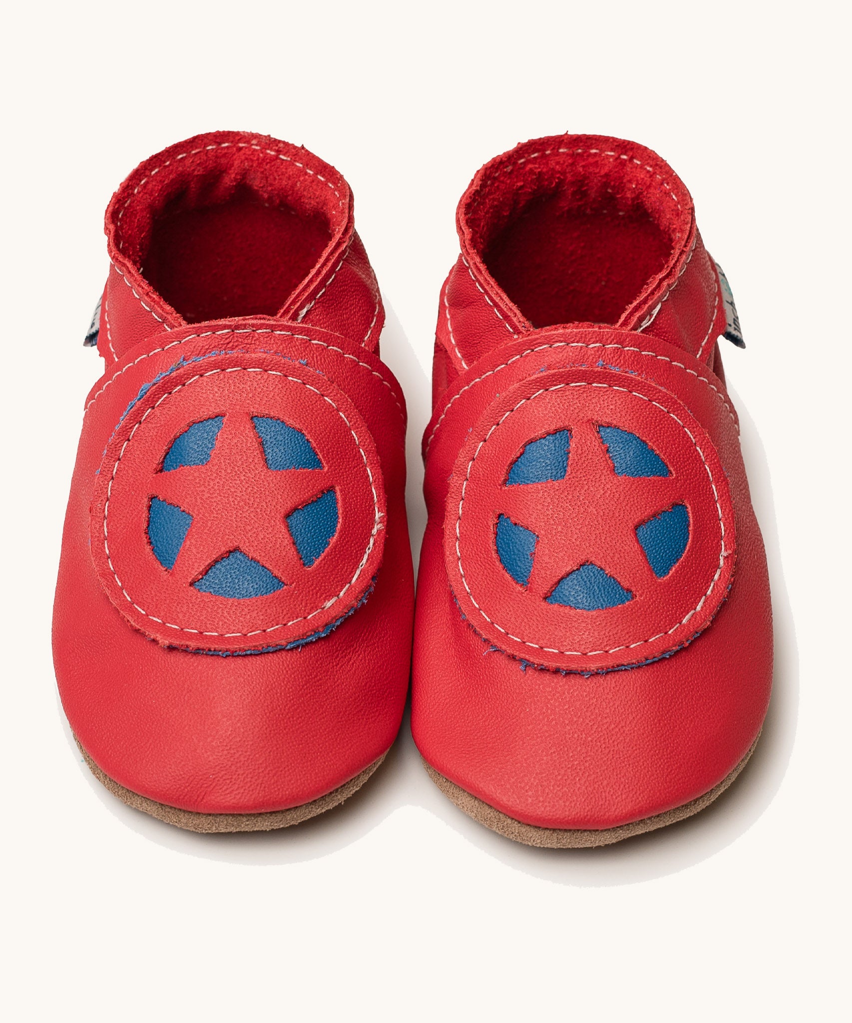 Inch Blue superkid red baby shoes available at Babipur. A soft red baby leather shoe with a red and blue star shield design on each shoe. Features elastic ankle cuffs for a secured fit